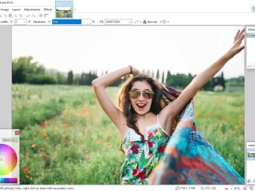 Una chica sonriente con gafas de sol y un pañuelo colorido en un campo de flores, editada en el **foto software** Paint.net.