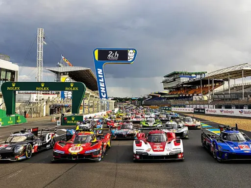 Startaufstellung für das 24-Stunden-Rennen von Le Mans. Rennwagen stehen bereit, die Spannung ist greifbar.