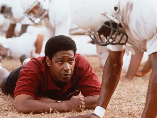 Denzel Washington, allenatore in un film sportivo, ispira la sua squadra. Storie vere di trionfo e determinazione.