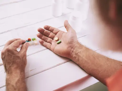 Mano che prende pillole da un portapillole. Speranza di guarigione con pembrolizumab.