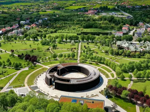 Widok z lotu ptaka na park i tężnię solankową w Busku-Zdroju. W oddali widać zabudowania i zielone wzgórza. Sanatoria w Busku-Zdroju oferują relaks i zdrowie.