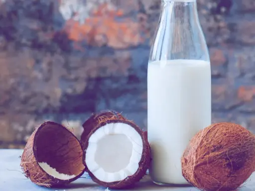 Frische Kokosnüsse und eine Flasche Kokosmilch, bereit zum Kokosmilch einfrieren.
