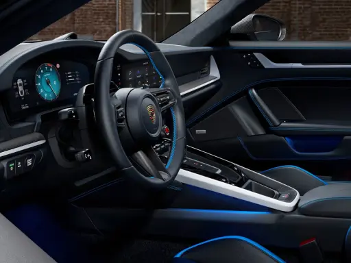 Der porsche 911 innenraum mit blauen Akzenten und digitalem Cockpit. Luxuriöses Leder und Carbon-Details.