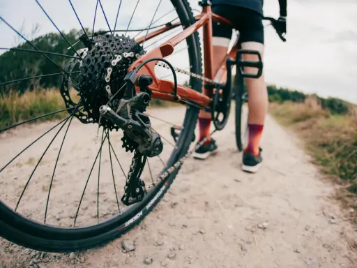 Rowerzysta na szutrowej drodze. Długość korby a wzrost to klucz do komfortowej jazdy.