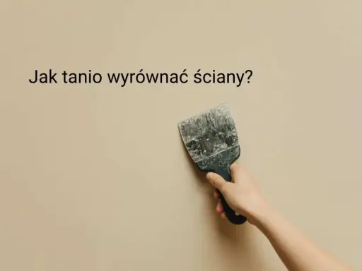 Ręka trzyma szpachelkę przy beżowej ścianie, szukając pomysłu na krzywe ściany.