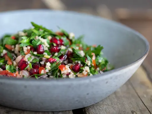 Frischer Tabouleh-Salat mit Granatapfelkernen, Petersilie und Bulgur. Ein köstliches tabouleh rezept für den Sommer.