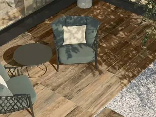 Aménager une terrasse moderne avec des fauteuils confortables, une table basse et un sol imitation bois. L'ombre des arbres crée une atmosphère paisible.