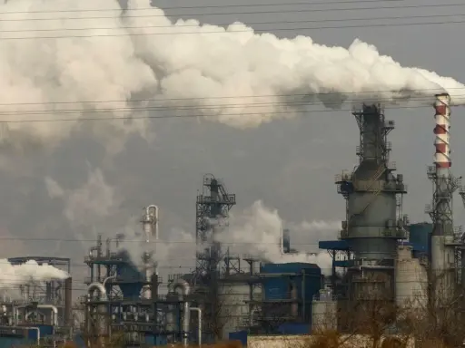 Rauchschwaden steigen aus einer Industrieanlage auf, die die Energieproduktion in China symbolisiert.