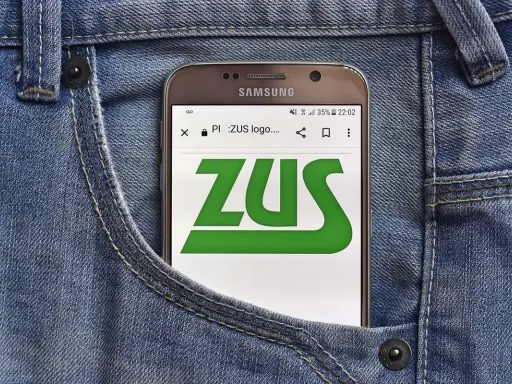 Telefon w kieszeni dżinsów wyświetla logo ZUS. Sprawdź, jak sprawdzić wysokość emerytury w ZUS PUE.