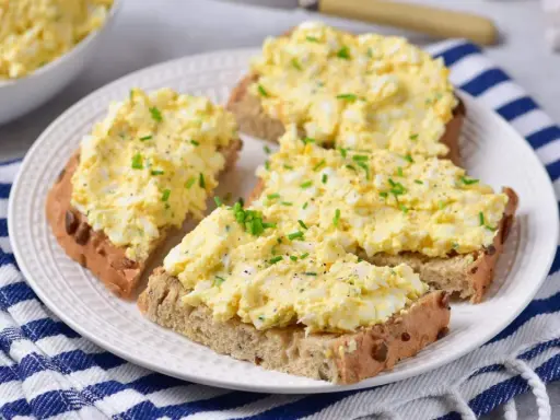 Pyszna pasta z jajek na chlebie, posypana szczypiorkiem i pieprzem. Idealna na szybkie śniadanie lub przekąskę.