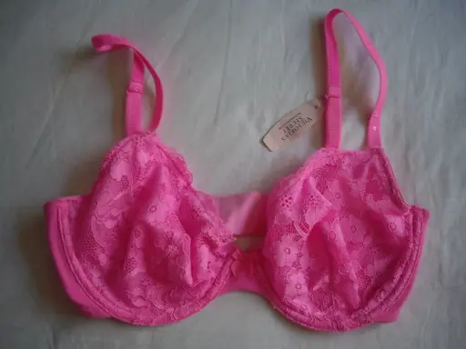 Reggiseno rosa acceso con pizzo floreale, spalline regolabili e un piccolo fiocco al centro. Taglia coppa DD.
