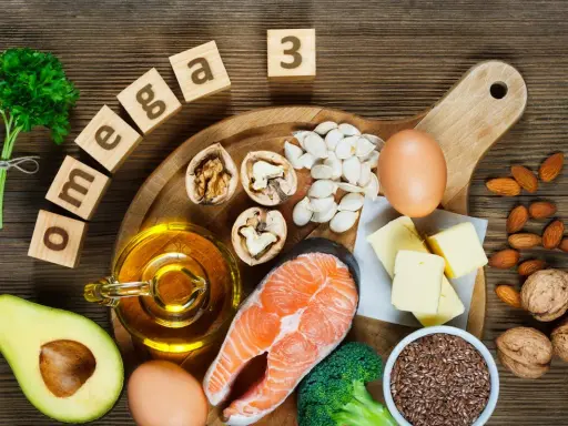 Assortiment d'aliments riches en oméga 3 : saumon, noix, avocat, œufs, huile, graines de lin, amandes, brocolis et beurre.