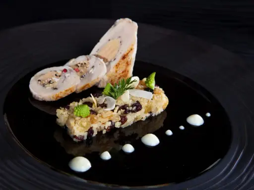 Un roulé de volaille farci au foie gras, accompagné d'un riz aux fruits secs et légumes verts, une spécialité Jura.