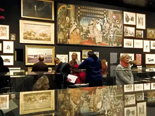 Wystawa w Krakowie, gdzie można podziwiać obrazy i rzeźby. Wiele osób zwiedza ekspozycję, ciesząc się darmowymi muzeami.