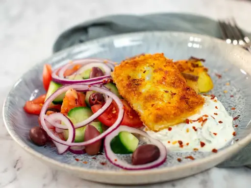 Krispigt panerad fisk med grekisk sallad och tzatziki. Ett perfekt fetaost recept för en lätt lunch.