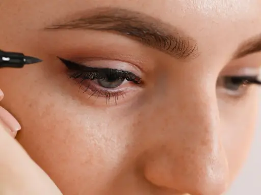 Application d'un trait d'eyeliner permanent pour un regard intense.