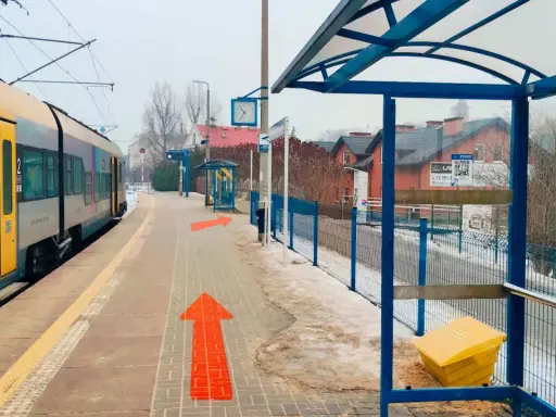 Pociąg na stacji, strzałki wskazują drogę. Tak jak dojechać z Krakowa do Wieliczki.
