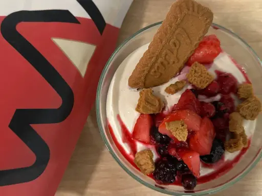 Leckere vegane Smoothie Bowl mit frischen Beeren, Kekskrümeln und einem Lotus-Keks.