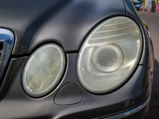 Zmatowiałe lampy samochodu, które wymagają polerowania. Zastanawiasz się, ile kosztuje polerowanie lamp?