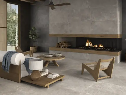 Salón moderno con chimenea encendida, sofá blanco y suelo de cemento pulido.