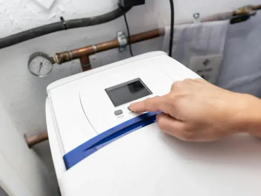 Main d'une personne appuyant sur le bouton "SET" d'un adoucisseur d'eau. Le manomètre indique la pression. Le 16 c'est quoi ?