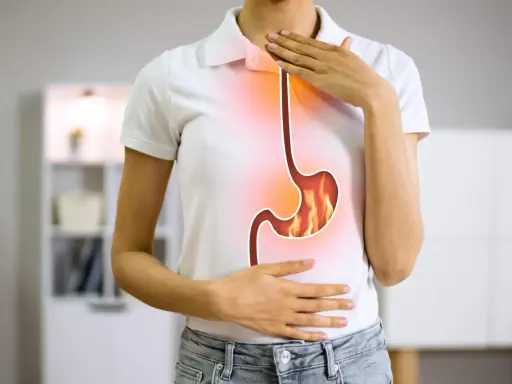 Persona con bruciore di stomaco, illustra la differenza tra pantoprazolo e omeprazolo per alleviare il disturbo.