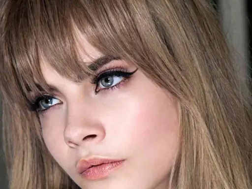 Primer plano de una mujer con flequillo rubio desfilado, delineado de ojos dramático y labios rosados. Muestra varios tipos de flequillo.