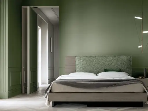 Camera da letto con pareti verde bosco, letto moderno con testiera tessuta e lampada geometrica.
