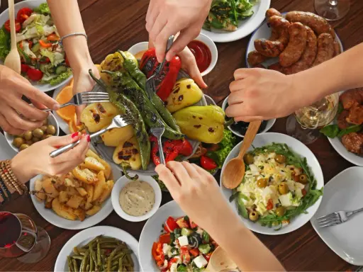 Un repas convivial avec des spécialités du Luberon : légumes grillés, saucisses, pommes de terre et salades.