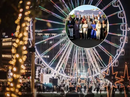 Eine Gruppe feiert bei Wonderland Lisboa vor einem beleuchteten Riesenrad.