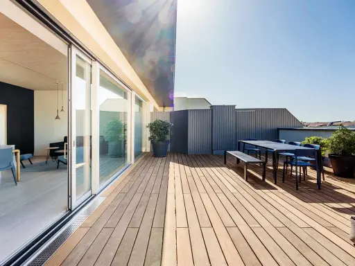 Modernes Einfamilienhaus mit großzügiger dachterrasse. Holzboden, Sitzgruppe und Pflanzen laden zum Verweilen ein.