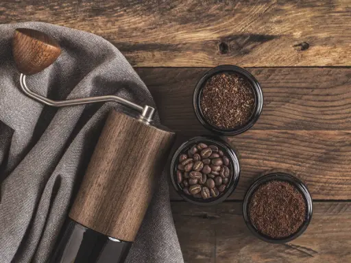 Holz-Kaffeemühle mit drei Behältern: ganze Bohnen, grob gemahlener und feiner, kleiner brauner Kaffee.