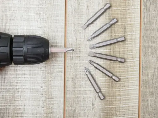 Taladro con varios tipos de puntas de destornillador dispuestas en abanico.
