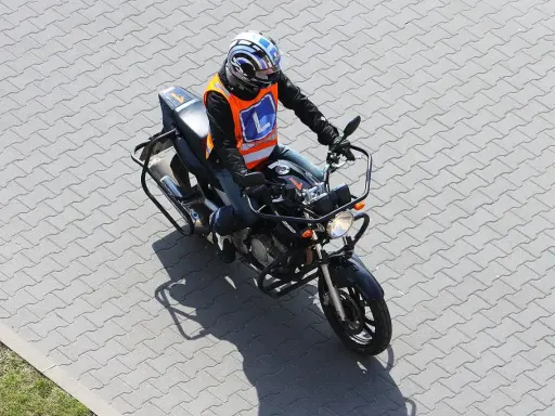 Osoba w kamizelce z literą "L" na motocyklu, przygotowuje się do egzaminu na prawo jazdy kategorii A2. Od ilu lat można zdawać?