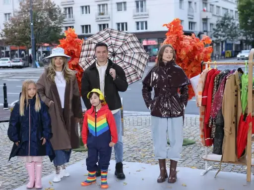 Rodzina prezentuje stylowe stylizacje na deszczowe dni: płaszcze, kalosze i kolorowe parasole.