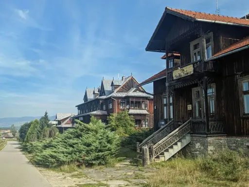 Drewniane wille w osadzie Czorsztyn, z charakterystyczną architekturą i zielenią, zapraszają do podróży w czasie.