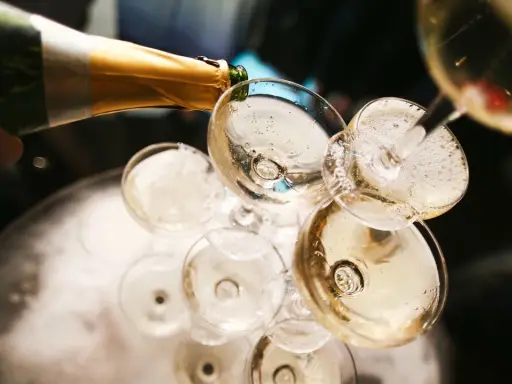 Champagner wird in Gläser gegossen, ein Moment, der die Champagner Geschichte feiert.