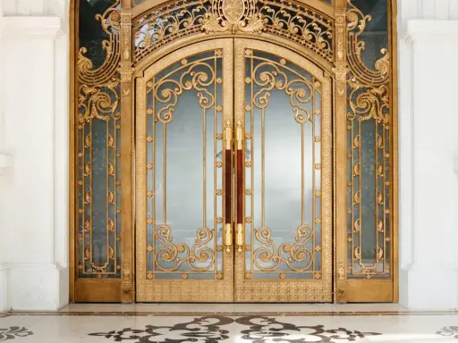 Prunkvolle goldene Doppeltür im **Art déco Baustil** mit filigranen Verzierungen und Marmorboden.