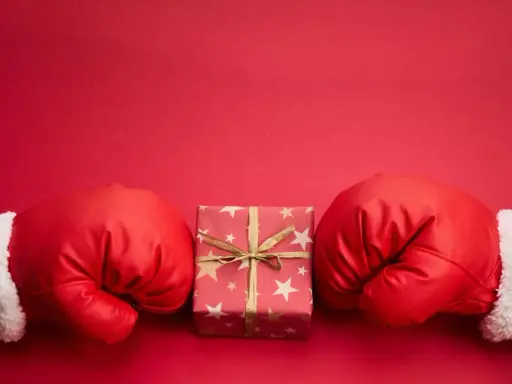 Rękawice bokserskie w świątecznym stylu otaczają prezent. Czy to zapowiedź, boxing day co to znaczy?