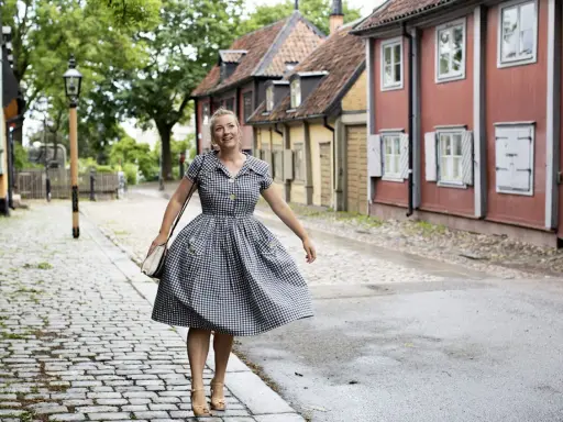 Kvinna i rutig klänning på kullerstensgata, inspirerad av Elsa Billgrens blogg.