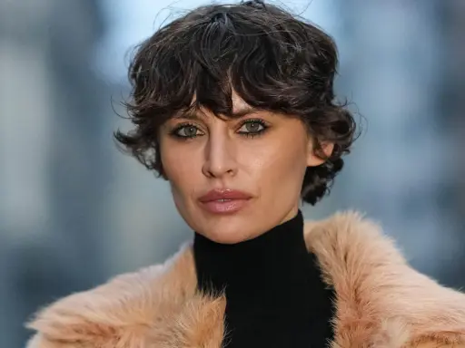 Eine Frau mit einem modernen Fade Cut und einem Pelzmantel.