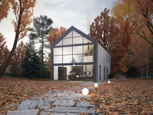Maison moderne avec un grand pignon vitré, entourée d'arbres aux couleurs d'automne. Un chemin de dalles mène à la porte d'entrée.