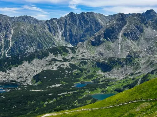 Tatry widziane z trasy turystycznej. Jeziora w dolinie, skaliste zbocza i zielone hale zachęcają do odkrywania piękna Zakopanego.