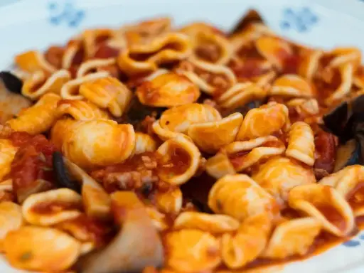 Orecchiette alla tarantina con melanzane e pomodoro, un piatto ricco e saporito.