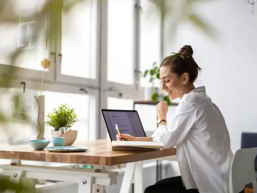 Uśmiechnięta kobieta pracuje przy laptopie, planując swój **ecommerce dropshipping**. Sukces w biznesie online!