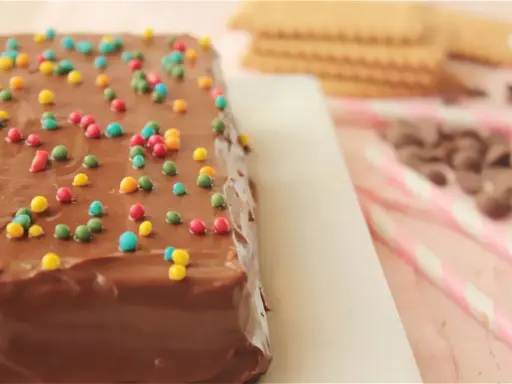 La tarta de la abuela, cubierta de chocolate y chispas de colores, lista para ser disfrutada.