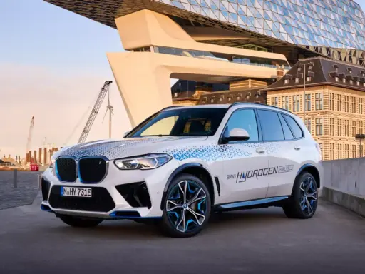 BMW iX5 Hydrogen, ein Vorreiter unter den BMW Elektro Modellen, mit futuristischer Architektur im Hintergrund.