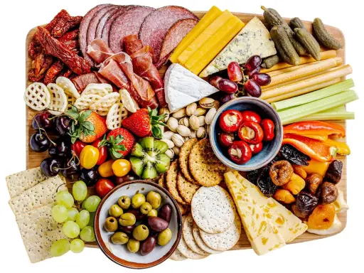 En generös bricka med kall mat: salami, skinka, ostar, oliver, frukt, grönsaker och kex. Perfekt för en festlig tillställning.