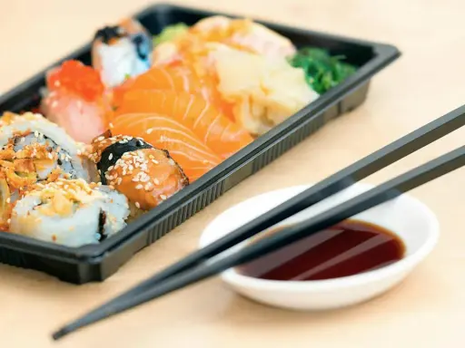 En låda med sushi och sashimi, redo att ätas. Perfekt för den som vill **springa efter mat** utan att kompromissa med smaken.