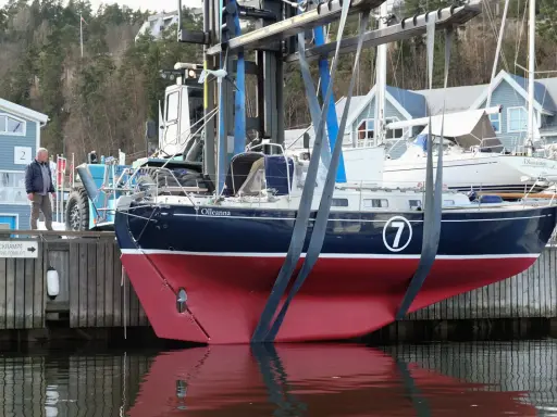 Ein Mann beobachtet, wie ein Rustler 36 namens "Olleanna" mit einem Kran aus dem Wasser gehoben wird.